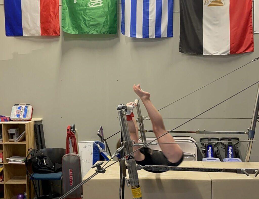 Girl doing Kip on uneven bars