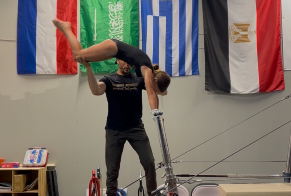 Girl doing baby giant on uneven bars