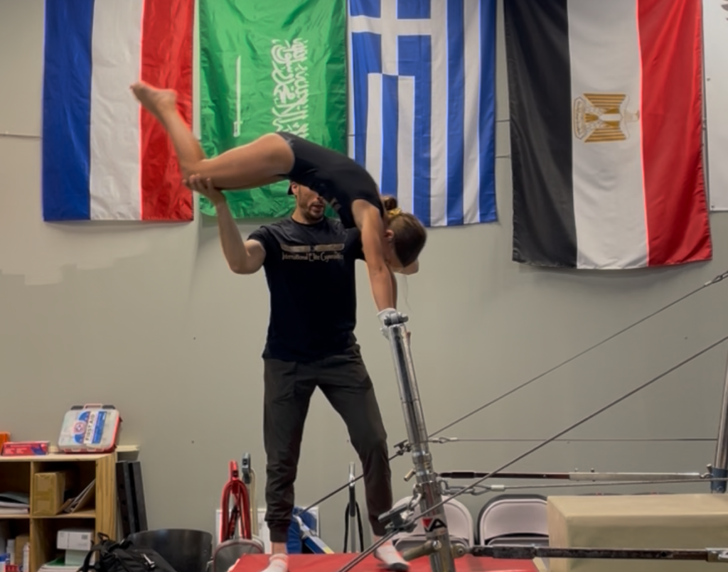 Girl doing baby giant on uneven bars